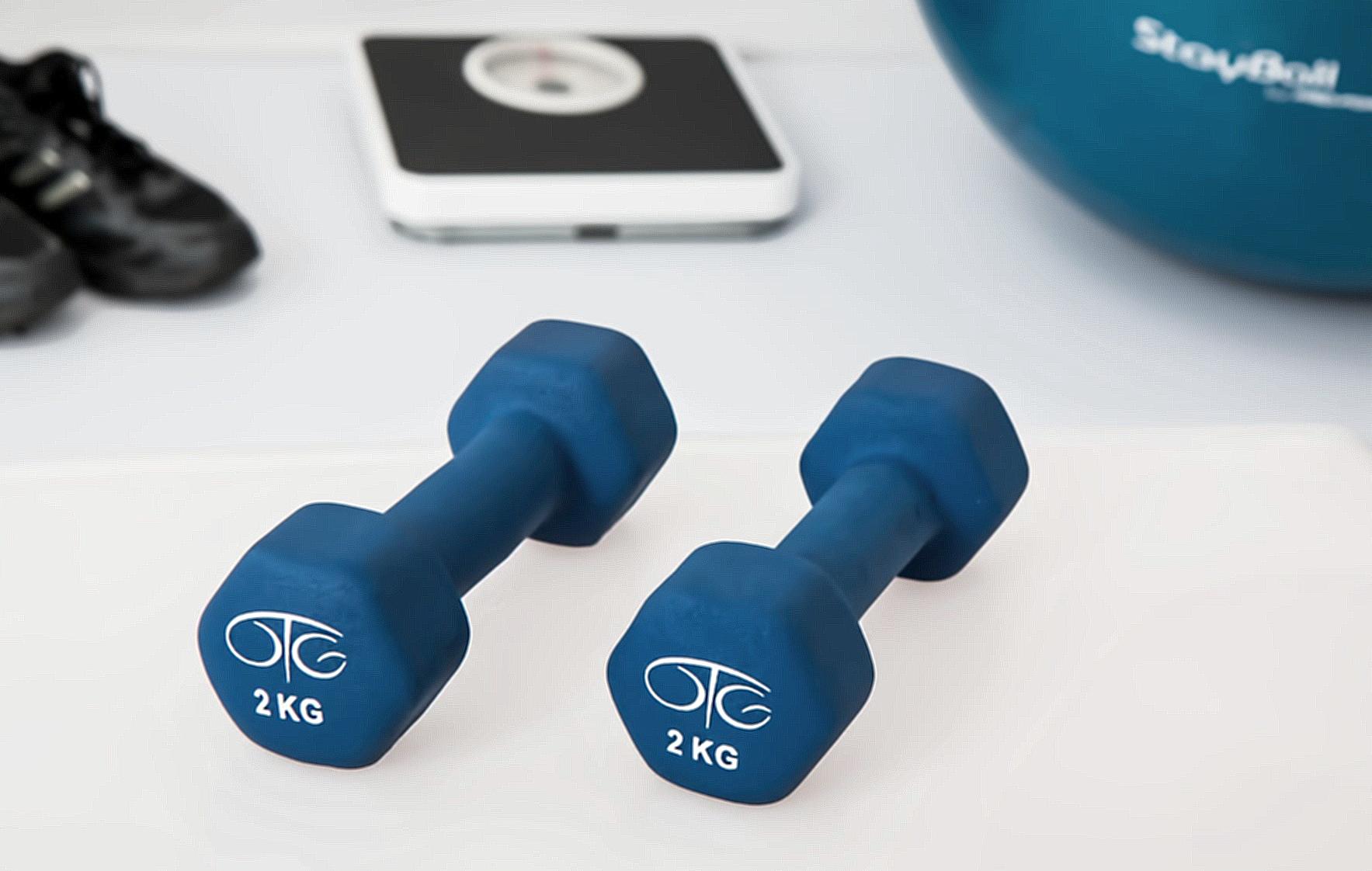 Two 2 Kg. Blue Hex Dumbbells on White Surface