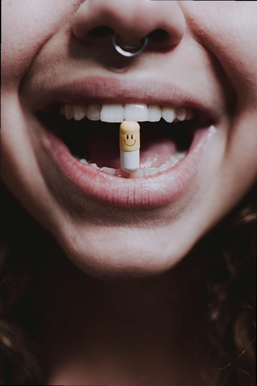 Faceless woman with pill in teeth and nose piercing